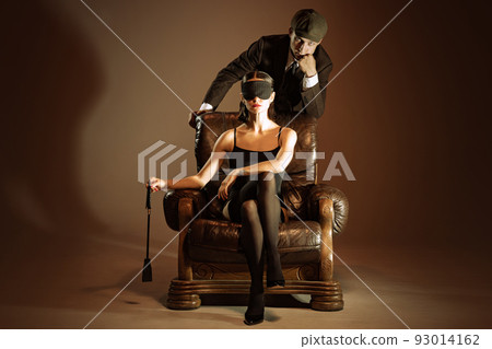 Creative portrait of man and woman in 1920s style fashion outfits isolated over dark brown background. Relationship, business, love, art, fashion Creative portrait of man and woman in 1920s style fashion outfits isolated over dark brown background. Relationship, business, love, art, fashion 93014162