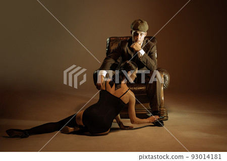 Vintage style portrait of man and woman in 1920s style fashion outfits isolated over dark brown background. Relationship, business, love, art, fashion Vintage style portrait of man and woman in 1920s style fashion outfits isolated over dark brown background. Relationship, business, love, art, fashion 93014181