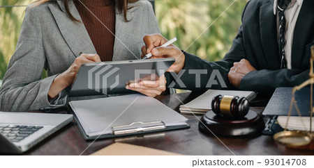 Business and lawyers discussing contract papers with brass scale on desk in office. Law, legal services, advice,  justice and law concept .. 93014708