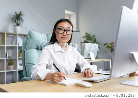 Portrait of young beautiful and successful Asian business woman, female employee smiling and looking at camera, accountant financier paperwork. 93015288