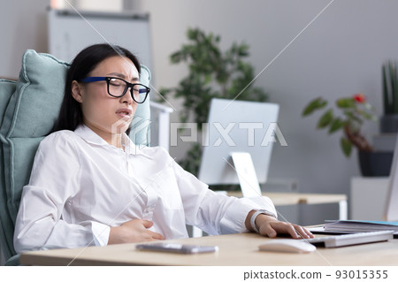 Asian business woman is sick in the office, has severe stomach pain, nausea and diarrhea. Asian business woman is sick in the office, has severe stomach pain, nausea and diarrhea. 93015355