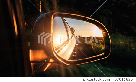Car sunset road mirror. Summer sun, highway car road reflection in mirror. Vacation trip concept. Car sunset road mirror. Summer sun, highway car road reflection in mirror. Vacation trip concept. 93015659