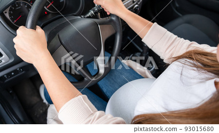 Pregnant woman driver. Beautiful smiling pregnancy woman driving car. Safety pregnant young mother drive concept. Pregnant woman driver. Beautiful smiling pregnancy woman driving car. Safety pregnant young mother drive concept. 93015680