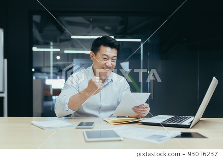 Businessman at work, Asian man reading a good letter from the bank about opening a credit line, the boss is pleased and celebrating the success of the company's finances 93016237