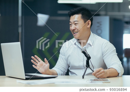 Business coach recording audio podcast, man working in office using professional microphone and laptop to record online stream, radio and podcast, Asian successful businessman 93016894