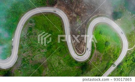 Aerial drone top view of a road curve winding through the mountains. Aerial drone top view of a road curve winding through the mountains. 93017865
