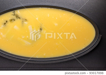 beaten eggs and cheese in omelet cooker 93017898