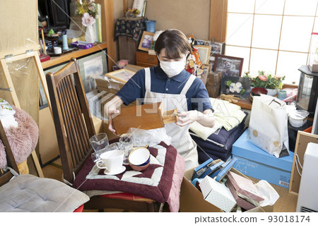 Female worker cleaning up a messy room 93018174