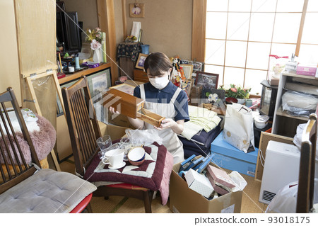 Female worker cleaning up a messy room 93018175