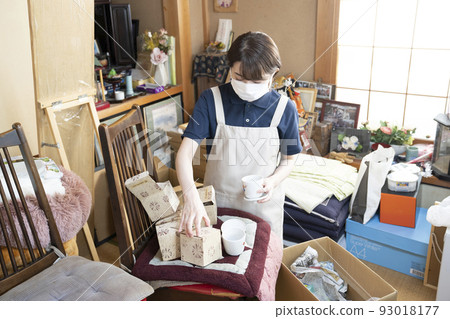 Female worker cleaning up a messy room 93018177