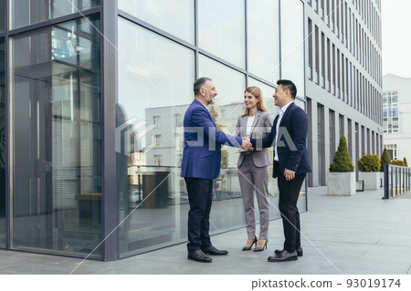 Business meet, colleagues happy team meet outside office, greet shake hands, diverse employees in business suit, man and woman business people Business meet, colleagues happy team meet outside office, greet shake hands, diverse employees in business suit, man and woman business people 93019174