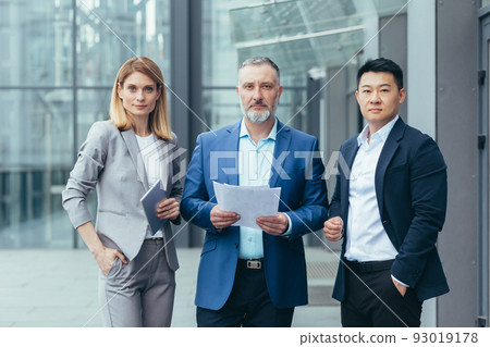Business team, male and female colleagues in business clothes near the office are looking at the camera serious and confident business people 93019178