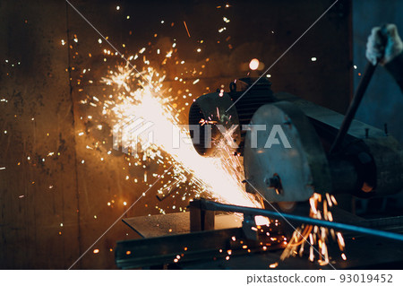 Metal processing with big compound mitre saw with circular blade. Sparks in metalworking at factory Metal processing with big compound mitre saw with circular blade. Sparks in metalworking at factory 93019452