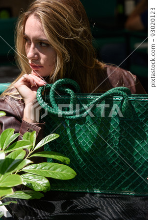 close-up photo of green leather bag in a hands of a beautiful woman 93020123