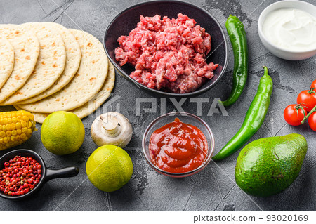 Traditional mexican tortilla ingredients with meat over grey background, side view. 93020169