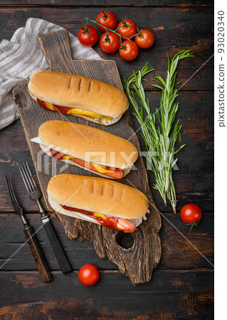 Hot dogs with ketchup, yellow mustard, on old dark  wooden table background, top view flat lay 93020340