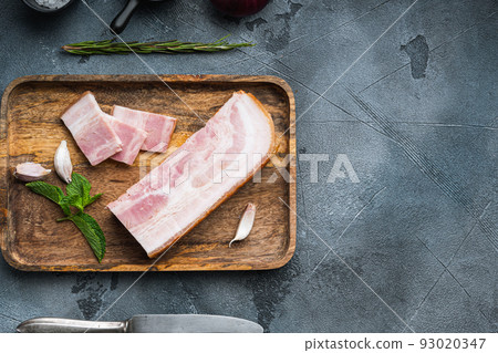 Smoked bacon, whole slab on grey textured background, top view with space for text Smoked bacon, whole slab on grey textured background, top view with space for text 93020347