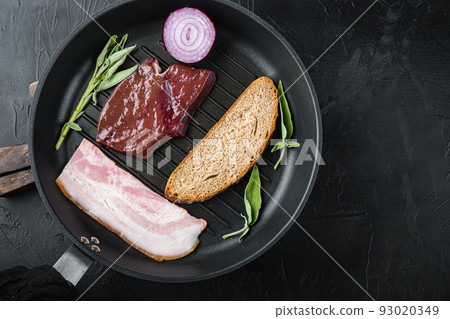 Raw liver sliced with bacon on grill pan on black surfacr, flat lay Raw liver sliced with bacon on grill pan on black surfacr, flat lay 93020349