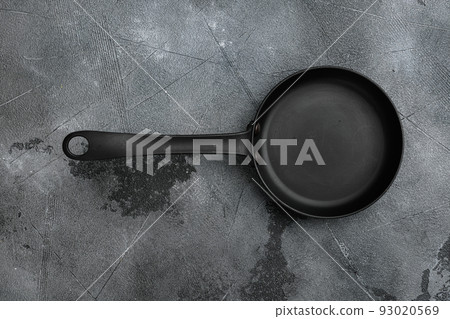 Cast iron frying pan with copy space for text or food with copy space for text or food, top view flat lay , on gray stone table background Cast iron frying pan with copy space for text or food with copy space for text or food, top view flat lay , on gray stone table background 93020569