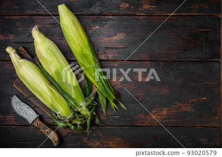 Ear of maize or corn, on old dark wooden table background, top view flat lay, with copy space for text Ear of maize or corn, on old dark wooden table background, top view flat lay, with copy space for text 93020579
