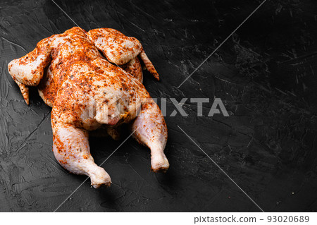 Tabaka chicken raw meat, on black dark stone table background, with copy space for text 93020689