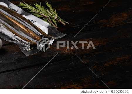 Smoked Lamprey seafood delicacy vacuum pack, on old dark wooden table background, with copy space for text Smoked Lamprey seafood delicacy vacuum pack, on old dark wooden table background, with copy space for text 93020691