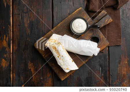 Chicken doner kebab, turkish street food, on cutting board, on old dark  wooden table background, top view flat lay, with copy space for text 93020740