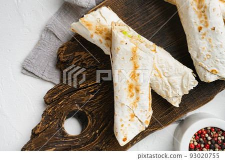 Doner kebab, a shawarma in a pit of fresh vegetables and meat, on cutting board, on white stone table background, top view flat lay 93020755
