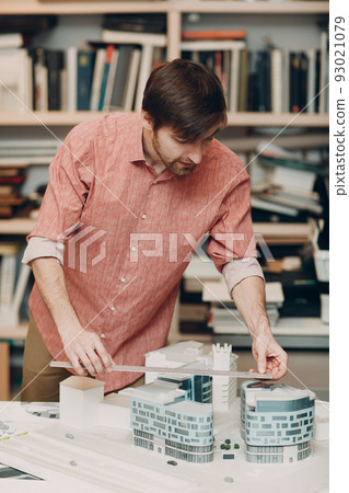 Architect with blueprints and layout buildings house design project at Bureau of Architecture. 93021079