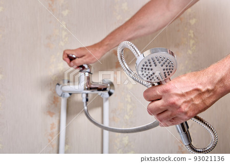 Plumber fixing leaky single handle shower faucet in bathroom. 93021136