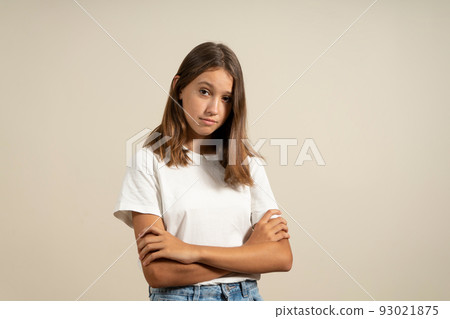 Portrait of angry hispanic teenage girl with arms crossed in warning gesture, isolated on beige studio background. Portrait of angry hispanic teenage girl with arms crossed in warning gesture, isolated on beige studio background. 93021875