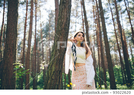 Young beautiful hippie woman walks in the summer forest laughs dances and enjoys life and nature 93022620