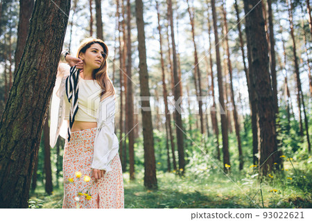 Young beautiful hippie woman walks in the summer forest laughs dances and enjoys life and nature 93022621
