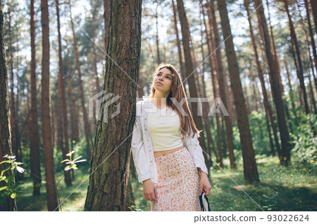 Young beautiful hippie woman walks in the summer forest laughs dances and enjoys life and nature 93022624