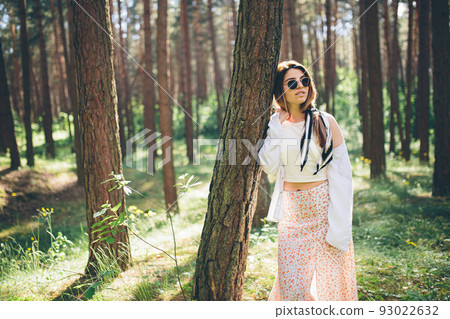 Young beautiful hippie woman walks in the summer forest laughs dances and enjoys life and nature 93022632