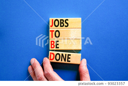 JTBD jobs to be done symbol. Concept words JTBD jobs to be done on wooden blocks on beautiful blue background. Businessman hand. Business and JTBD jobs to be done concept. Copy space. 93023357