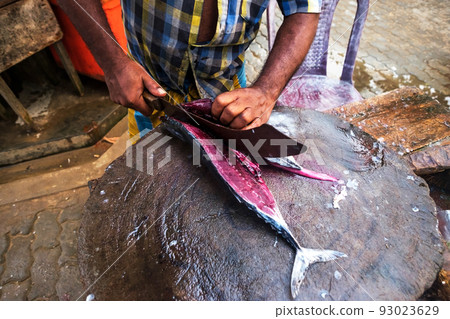 Man cutting fresh tuna with huge knife in Weligama In Sri Lanka. Man cutting fresh tuna with huge knife in Weligama In Sri Lanka. 93023629