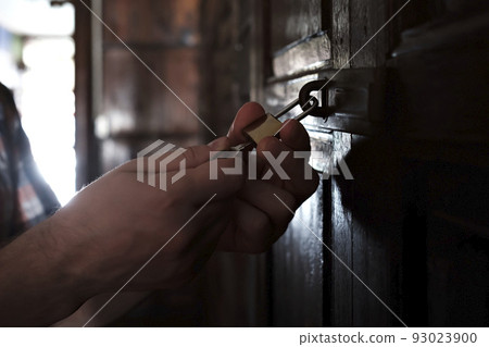 Caucasian man opening old wooden door Caucasian man opening old wooden door 93023900