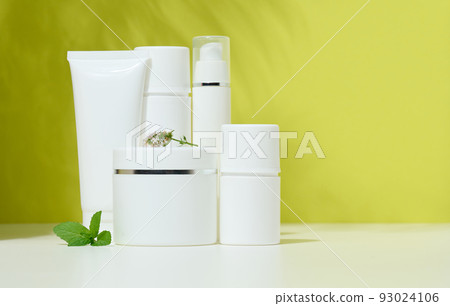White plastic container tube, a jar with a lid for cosmetics on a green background 93024106