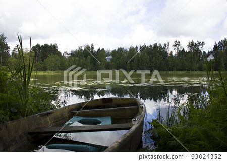 flooded wooden boat on the shore of a forest lake. on the other side of the house of rich people. living in an ecologically clean area. coniferous forest flooded wooden boat on the shore of a forest lake. on the other side of the house of rich people. living in an ecologically clean area. coniferous forest 93024352