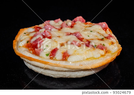 Homemade mini pizza baking on tray in electric oven, black background 93024679