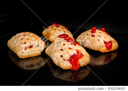 Four baked homemade buns with red strawberry jam in electric oven Four baked homemade buns with red strawberry jam in electric oven 93024693