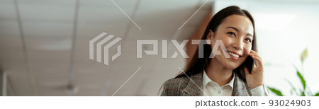 Asian business woman making a phone call and smiling at office 93024903