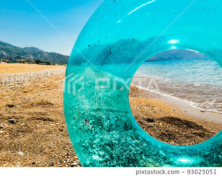 Blue inflatable swim ring float and sunglasses on the beach. Blue inflatable swim ring float and sunglasses on the beach. 93025051
