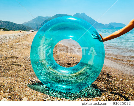 Blue inflatable swim ring float and sunglasses on the beach. Blue inflatable swim ring float and sunglasses on the beach. 93025052