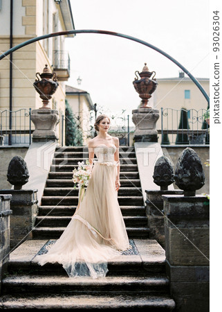 Bride in a long dress on the steps of an old villa. Como. Italy Bride in a long dress on the steps of an old villa. Como. Italy 93026304