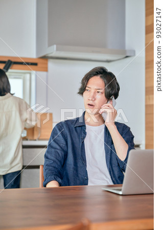 A man who calls during telework and a woman who does housework A man who calls during telework and a woman who does housework 93027147
