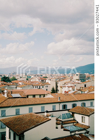Tiled roofs of houses in Florence against the backdrop of mountains. Italy Tiled roofs of houses in Florence against the backdrop of mountains. Italy 93027441