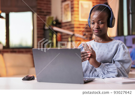 African american woman having online job interview while sitting in modern home office. Female remote worker wearing headphones and talking on videocall, businesswoman on teleconference African american woman having online job interview while sitting in modern home office. Female remote worker wearing headphones and talking on videocall, businesswoman on teleconference 93027642
