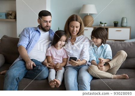 Couple and kids enjoy new mobile app using smartphone Couple and kids enjoy new mobile app using smartphone 93028093